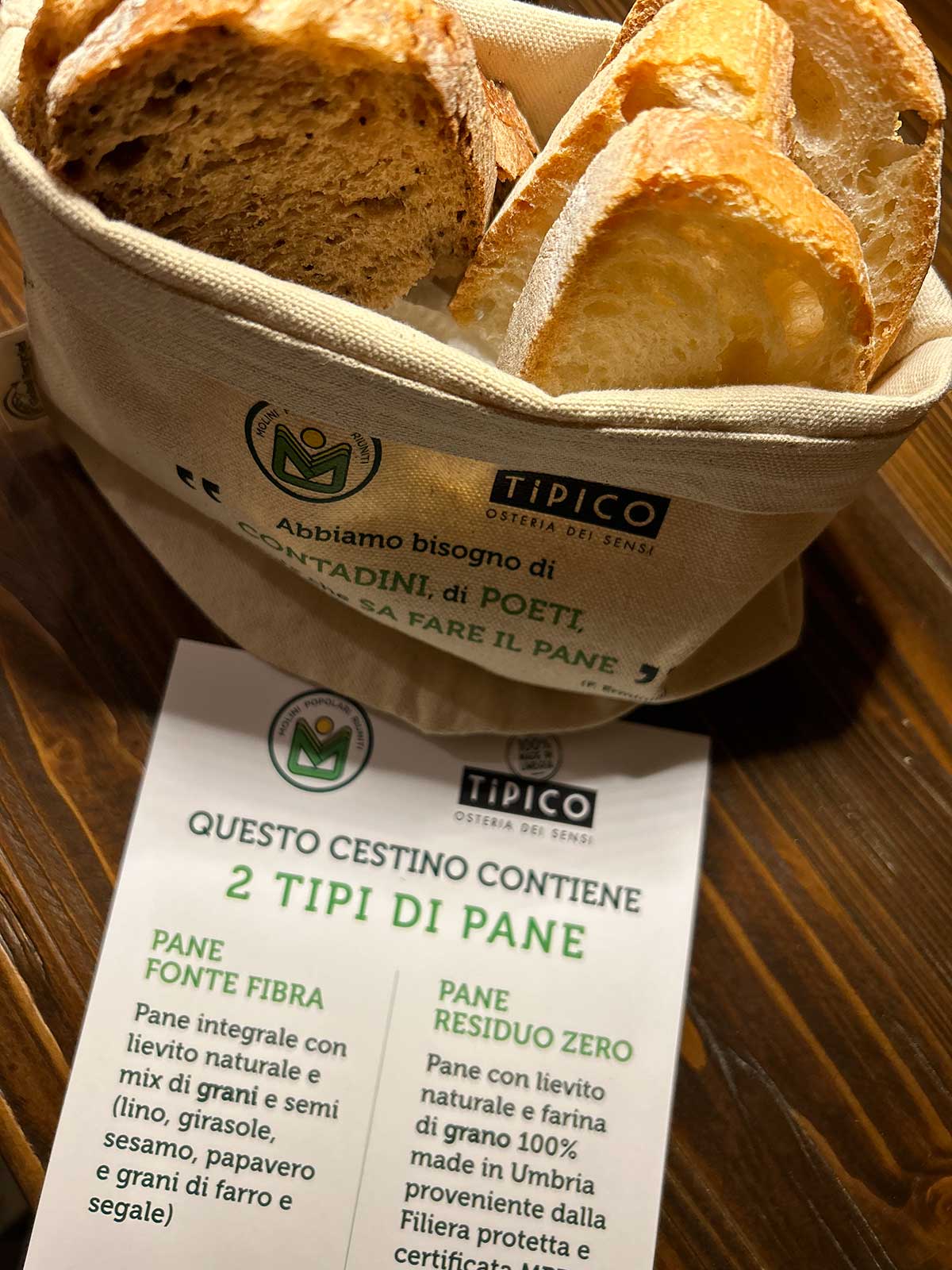 Basket with 2 types of bread: Fonte Fibra bread and Zero Residue bread. Tipico Osteria dei Sensi Montone Umbria Italy