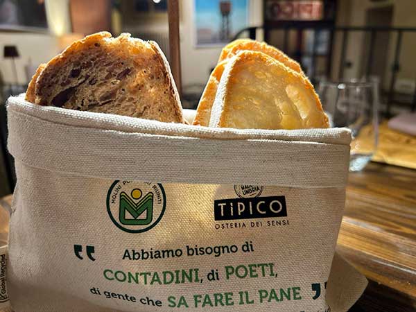 Basket with 2 types of bread: Fonte Fibra bread and Zero Residue bread. Tipico Osteria dei Sensi Montone Umbria Italy